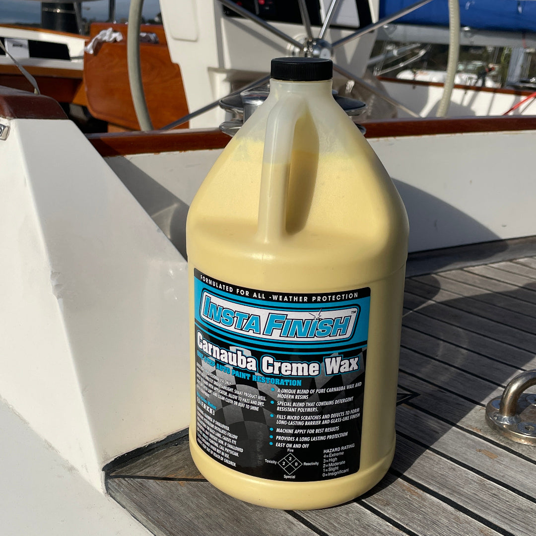 A one gallon bottle of Carnauba Creme wax sitting in the cockpit of a yacht with the steering wheel behind.