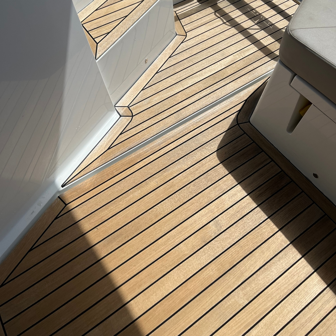 Teak Wood deck with white baseboards and shadows cast by sunlight after using Semco 2 part Cleaning Kit.